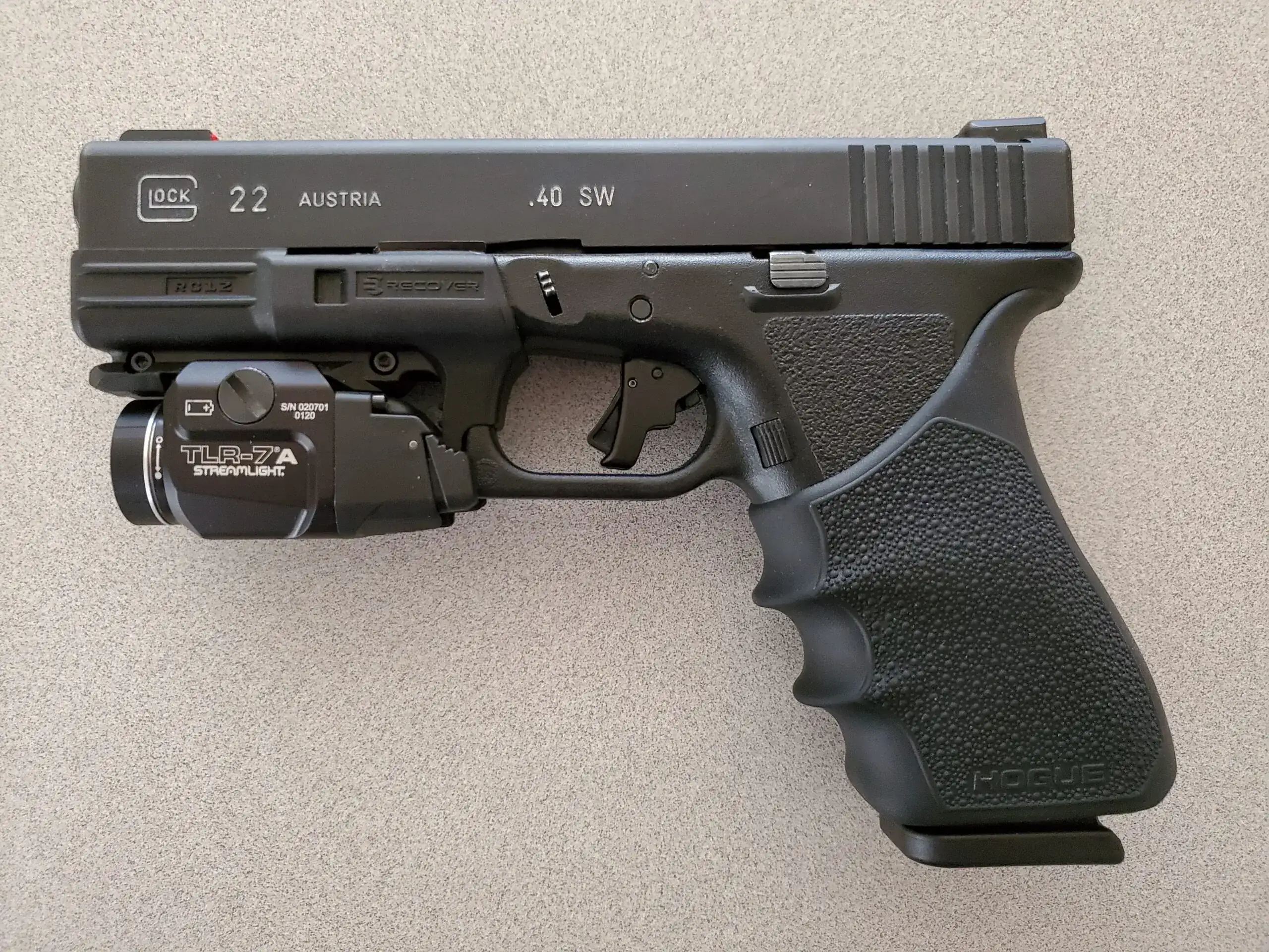 Glock 22 pistol chambered in .40 S&W equipped with a Streamlight TLR-7A tactical light and textured grip sleeve, showcasing common Glock 22 accessories for improved handling and visibility.