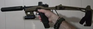 A hand holding a modified tactical firearm with attachments.