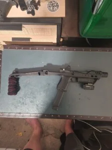 A firearm with an extended stock is resting on a table.