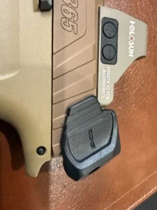 Close-up of a firearm with a mounted Holosun sight and visible model markings.