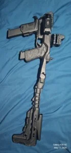 A black tactical firearm on a blue fabric background.